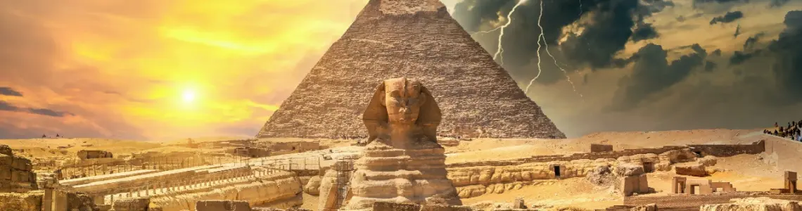 the sphinx and a pyramid in the evening as the sun begins to set