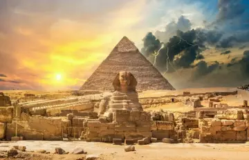 the sphinx and a pyramid in the evening as the sun begins to set