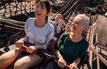 two young women enjoying the thrill of a roller coaster ride