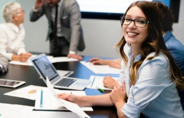 the face of confidence. a young woman in an office setting smiling at the camera with an open expression exuding confidence