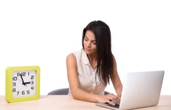 happy gamer on a laptop with a clock nearby