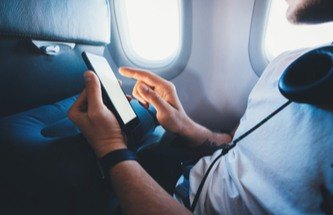 person travelling by plane while playing mobile slots